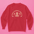Christmas sweatshirt with "SEASONS SCREAMINGS, DARKLING" text arched over a skull wearing Santa hat. Bats, flowers, and ornate designs surround the skull in vintage-inspired style.